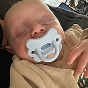 Ysahö a rejoint le concours — aidez-le/la à gagner de superbes lots ! baby, sleeping, pacifier, beige_clothing, hand, couch, indoor, face, child, infant, resting, cozy, home, soft_light, peaceful, young_child, blanket, person, relaxing, nursery
