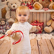 Laÿna a rejoint le concours — aidez-le/la à gagner de superbes lots ! blonde_hair, blue_eyes, candy_cane, child, christmas_theme, cute, festive, fluffy_decoration, gift_box, holiday_decor, holiday_spirit, indoor, portrait, red_ribbon, stuffed_animal, teddy_bear, toddler, white_sweater, winter_clothing, wooden_floor