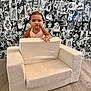 Aamiyah is registered to the contest to win money with this photo: toddler, child, baby, pink_dress, bow, small_couch, wood_floor, black_and_white_photos, wall_collage, pouty_face, portrait, indoor, cute, funny_expression, furniture, person, headwear, bracelet, smiling, background