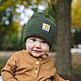 child, toddler, beanie, hat, brown_sweater, buttoned_shirt, outdoor, autumn, fall, trees, blurred_background, cute, portrait, young_child, face, smile, nature, seasonal, warm_clothing, daylight