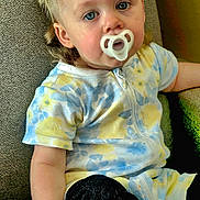 Zaiden is registered to the contest to win money with this photo: baby, blonde, bodypart, chair, clothing, couch, cushion, face, finger, furniture, hand, head, homedecor, pants, person, photography, portrait, shorts, sitting, t_shirt