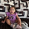 Zelda joined the competition — help win amazing prizes! toddler, child, girl, purple_shirt, butterfly, bow, pillow, blanket, couch, shoes, indoor, sitting, curious, face, hair, clothing, furniture, soft_texture, pattern, home