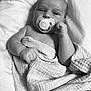 baby, infant, pacifier, blanket, wrapped, sleeping_area, portrait, monochrome, black_and_white, cute, child, newborn, skin, hand, face, peaceful, soft_texture, lying_down, closeup, resting