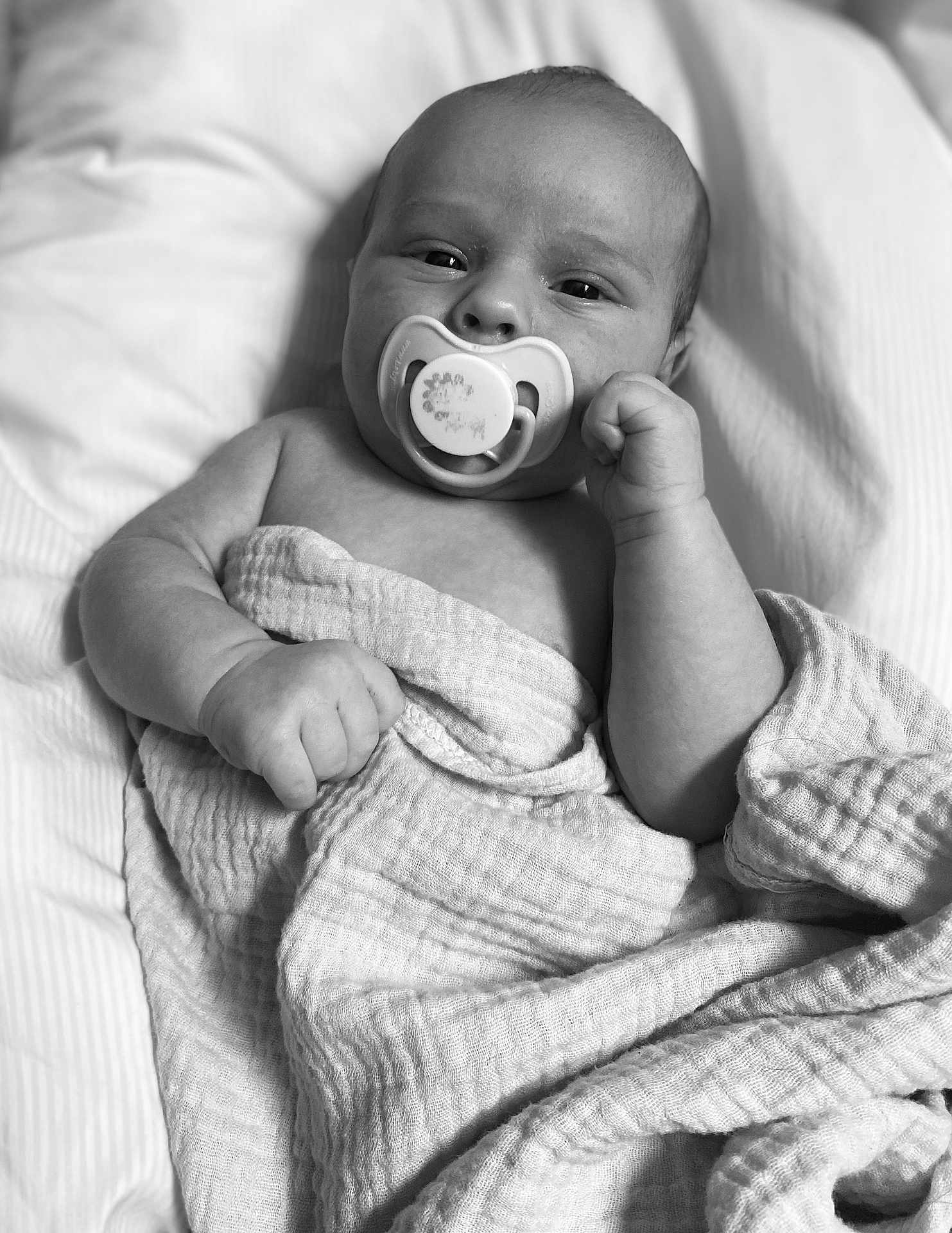 Brandon Jr is registered to the contest to win money with this photo: baby, infant, pacifier, blanket, wrapped, sleeping_area, portrait, monochrome, black_and_white, cute, child, newborn, skin, hand, face, peaceful, soft_texture, lying_down, closeup, resting
