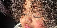 Azhainei is registered to the contest to win money with this photo: child, curly_hair, portrait, close_up, face, eyelashes, skin, sunlight, warm_light, cozy_clothing, jacket, button, peaceful, serene, sleepy, natural_light, texture, soft, young, person