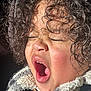 Azhainei is registered to the contest to win money with this photo: child, curly_hair, yawning, close_up, face, mouth_open, eyes_closed, sunlight, fleece_jacket, rosy_cheeks, texture, cozy, expression, portrait, person, natural_light, indoor, casual, cute, hair