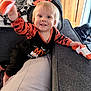 Liam is registered to the contest to win money with this photo: toddler, child, smiling, orange_clothing, pumpkin_pattern, sock, couch, dog, indoor, wooden_door, blanket, happy, playful, person, furniture, living_room, cute, young_child, home, pet