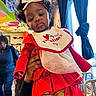 Sarai joined the competition — help win amazing prizes! baby, child, indoor, red_clothing, headband, curly_hair, bib, valentines_day, person, hand_holding, window, curtains, colorful_wall, art, people, gold_pants, dress, expression, portrait, cute