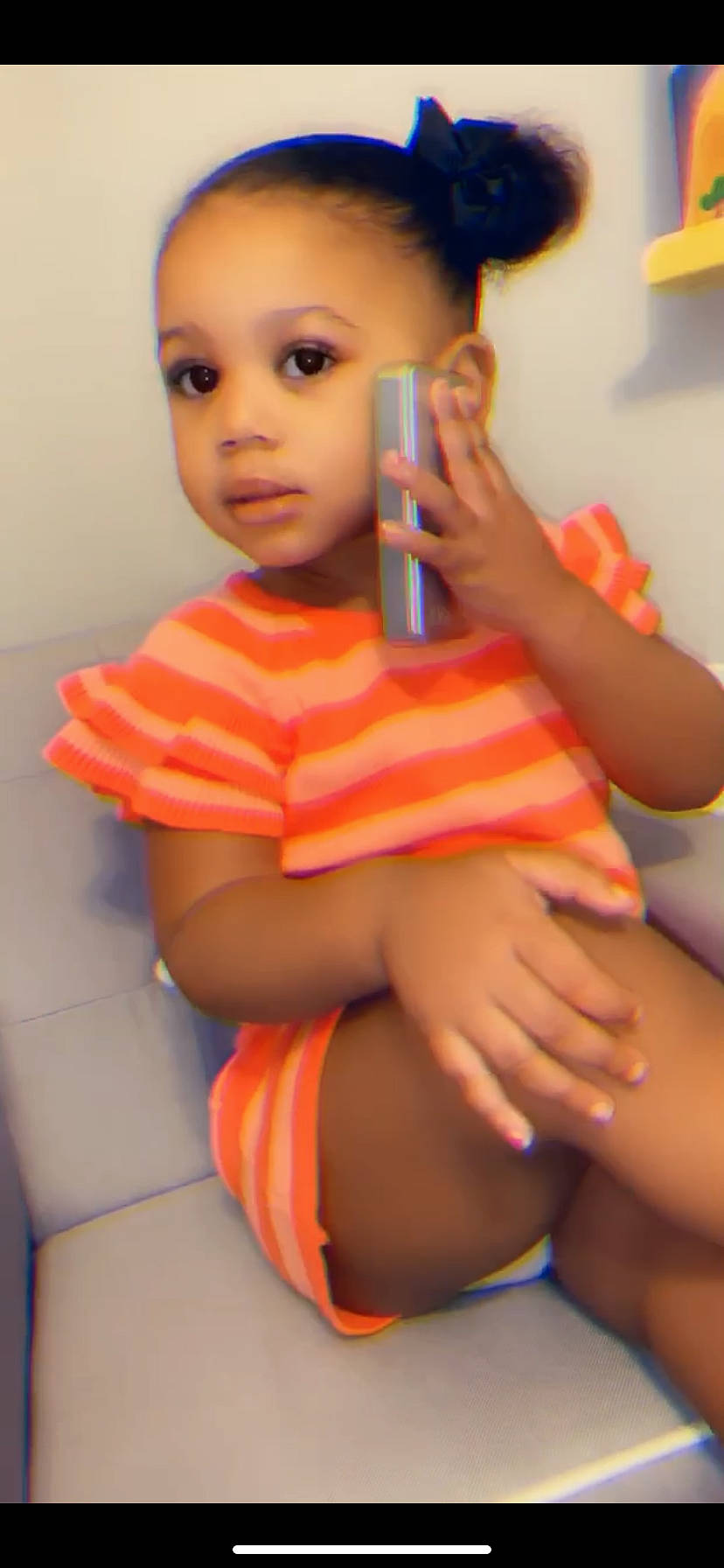 Leava is registered to the contest to win money with this photo: abdomen, black_hair, cheek, chest, child, face, finger, joint, leg, lip, long_hair, mouth, neck, orange, person, pigtail, skin, thigh, thumb, toddler