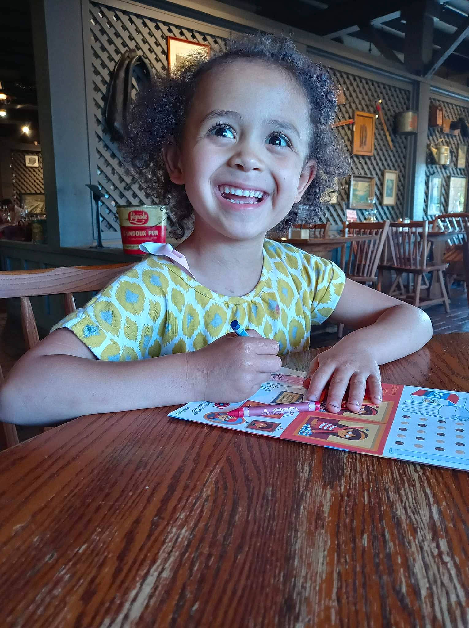 Aaylah joined the competition — help win amazing prizes! chair, child, desk, floor, flooring, fun, happy, hardwood, joy, leisure, person, room, sitting, smile, t_shirt, table, tableware, toddler, varnish, wood