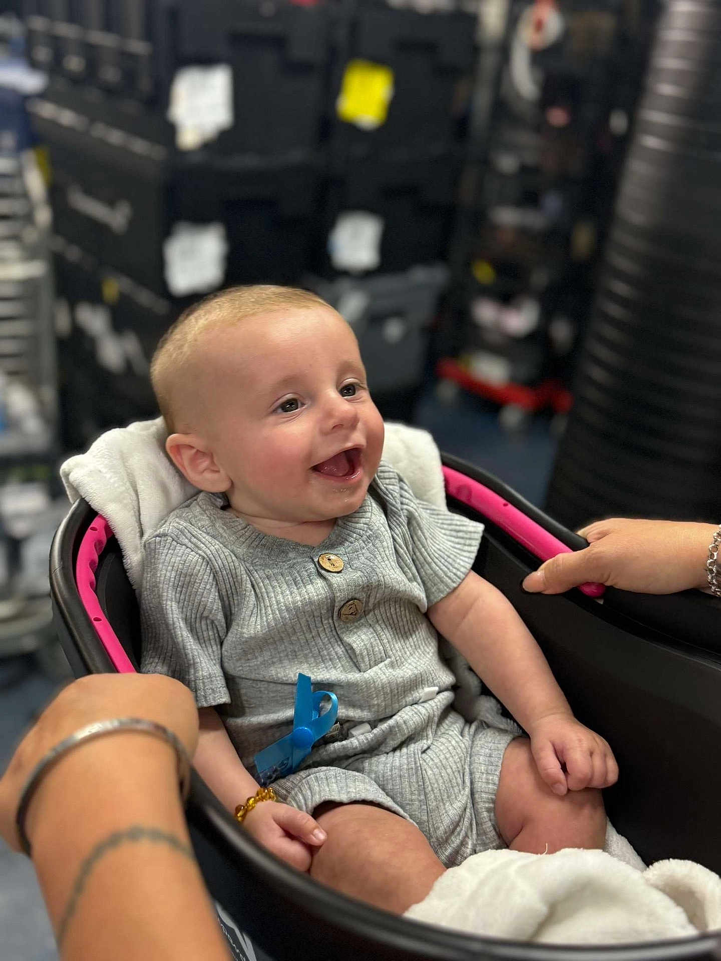 Hudson joined the competition — help win amazing prizes! baby, smiling, stroller, grey_outfit, wooden_buttons, hands, bracelet, infant, seat, happy, portrait, indoor, child, cute, person, young, clothing, blanket, closeup, comfort