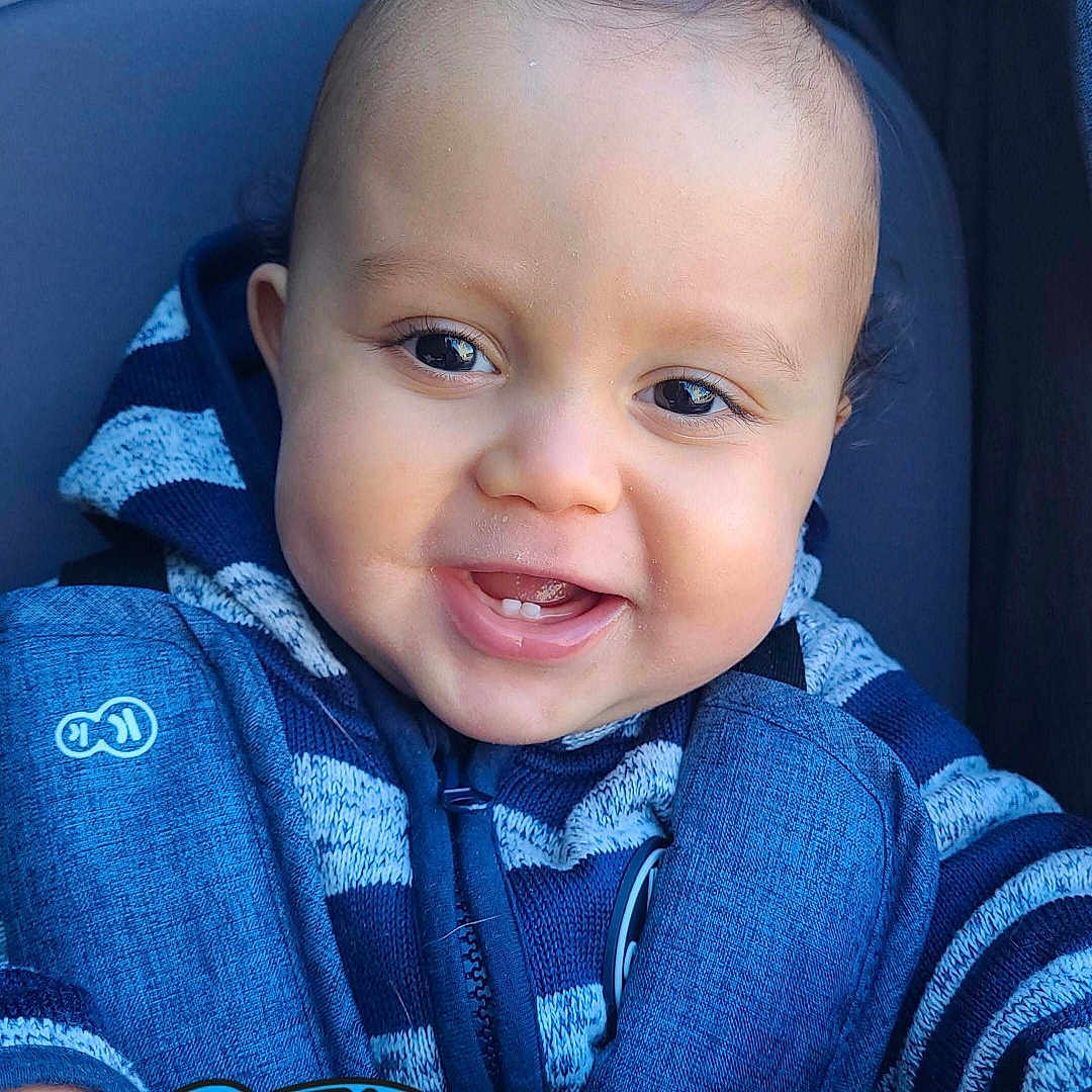 Milow a rejoint le concours — aidez-le/la à gagner de superbes lots ! baby, babylaughing, clothing, coat, cushion, face, happy, head, homedecor, hoodie, jacket, jeans, knitwear, laughing, pants, person, photography, portrait, smile, sweater