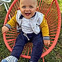 baby, blue_eyes, casual, chair, child, cute, daylight, fun, grass, happy, jacket, outdoor, person, playful, red_chair, relaxed, seat, smiling, socks, young_child