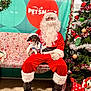 Stogey is registered to the contest to win money with this photo: santa_claus, dog, christmas_tree, holiday, festive, bench, pet_smart, gift, decoration, ornament, tinsel, hat, costume, beard, glasses, floor, indoor, celebration, pet, seasonal