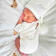 Levi is registered to the contest to win money with this photo: newborn, baby, sleeping, white_knit_outfit, white_hat, blanket, teddy_bear_pattern, soft_texture, infant, cute, peaceful, portrait, child, cozy, resting, indoors, warm, small, cute_face, wrapped