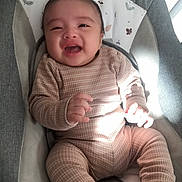 Ibrahim joined the competition — help win amazing prizes! baby, child, infant, smiling, laughing, clothing, brown, plaid, seat, baby_chair, cushion, indoor, person, cute, happy, hands, face, head, young, cozy