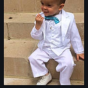 Gabriel participe au concours pour gagner de l'argent avec cette photo : accessory, bow_tie, boy, casual_pose, child, cute, footwear, formal_wear, outdoor, person, playful, portrait, short_hair, sitting, smiling, stairs, stone_steps, toddler, white_shoes, white_suit