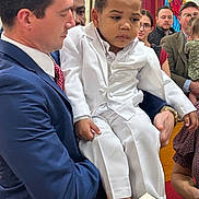 Ikemuefuna joined the competition — help win amazing prizes! audience, blue_suit, book, child, diverse, event, formal, glasses, holding, indoor, man, people, portrait, red_tie, religious_ceremony, serious, stained_glass, suit, white_suit, woman