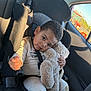 toddler, child, car_seat, teddy_bear, stuffed_animal, seatbelt, car_interior, window, sunlight, clothing, cute, portrait, serious_expression, plush, transportation, vehicle, road_trip, seat, young_child, comfort