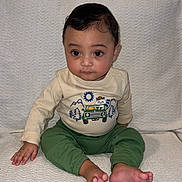 Zayan is registered to the contest to win money with this photo: baby, blanket, child, clothing, curtains, cute, eyes, face, feet, hair, hand, indoor, infant, pants, portrait, shirt, sitting, smiling, texture, young