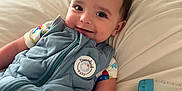 Jack is registered to the contest to win money with this photo: baby, smiling, blue_outfit, bed, pillow, baby_bottle, infant, cute, child, lying_down, soft_toys, comfortable, indoors, cozy, sleepwear, portrait, young_child, happy, baby_clothing, resting