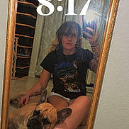Milo joined the competition — help win amazing prizes! person, dog, french_bulldog, mirror, selfie, seated, pet, indoors, bedroom, floor, ornate_frame, reflection, tattoos, black_shirt, shorts, sandals, fashion, curtain, furniture, clock_text