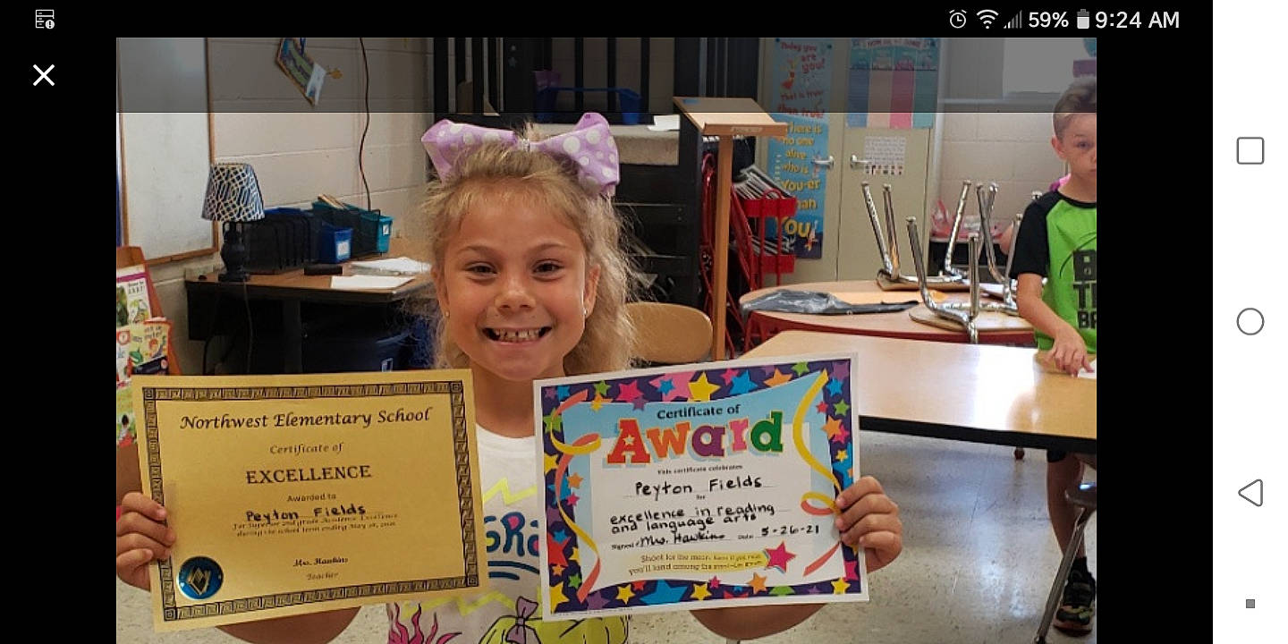 Peyton is registered to the contest to win money with this photo: art, artist, chair, child, child_art, desk, education, event, fun, handwriting, happy, joy, learning, office_supplies, person, room, smile, t_shirt, table, toddler