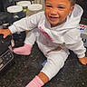 Ahniaya Jones is registered to the contest to win money with this photo: child, toddler, smiling, sitting, hoodie, pink_socks, kitchen, countertop, curly_hair, happy, indoor, appliance, jars, person, cute, portrait, young_child, candid, playful, text_overlay