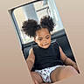child, car_interior, black_clothing, curly_hair, pigtails, shorts, heart_pattern, seat, window, daylight, casual, portrait, cute, thinking, young_child, sitting, indoors, relaxed, skin, person