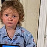 Kairo joined the competition — help win amazing prizes! child, toddler, boy, curly_hair, blue_shirt, handheld_device, gaming, indoor, portrait, serious_expression, light_skin, standing, technology, casual_clothing, young, person, focused, device_screen, home, playing
