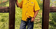 Xayden joined the competition — help win amazing prizes! child, boy, yellow_shirt, jeans, boots, fence, wooden_fence, barn, red_barn, wildflowers, grass, outdoor, nature, sunset, portrait, smiling, casual_pose, countryside, greenery, scenic