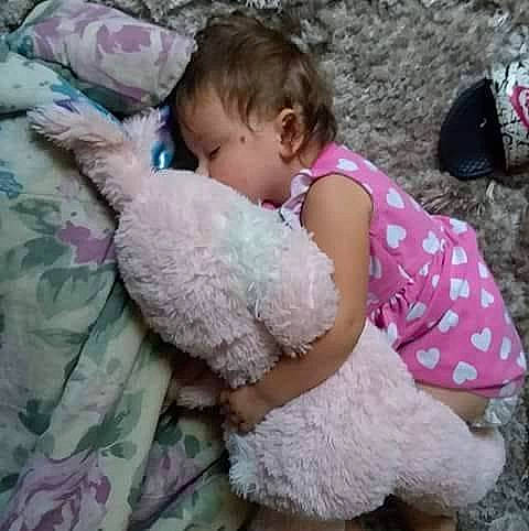 Tessa is registered to the contest to win money with this photo: bedtime, child, day, face, fun, girl, head, infant, nap, nose, person, pink, play, product, skin, sleep, stuffed_toy, teddy_bear, textile, toddler