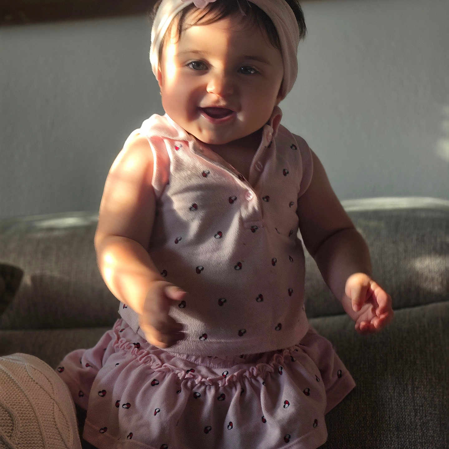 Danelly Anais is registered to the contest to win money with this photo: baby, child, infant, smiling, happy, portrait, headband, flower, pink_outfit, dress, heart_pattern, sitting, couch, indoor, sunlight, shadow, face, eyes, hands, photography