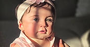 Danelly Anais joined the competition — help win amazing prizes! child, baby, toddler, portrait, face, eyes, sitting, pink_clothing, floral_headband, hair_accessory, dress, patterned_clothing, earring, indoor, warm_lighting, sunlight, window_light, closeup, person, photography