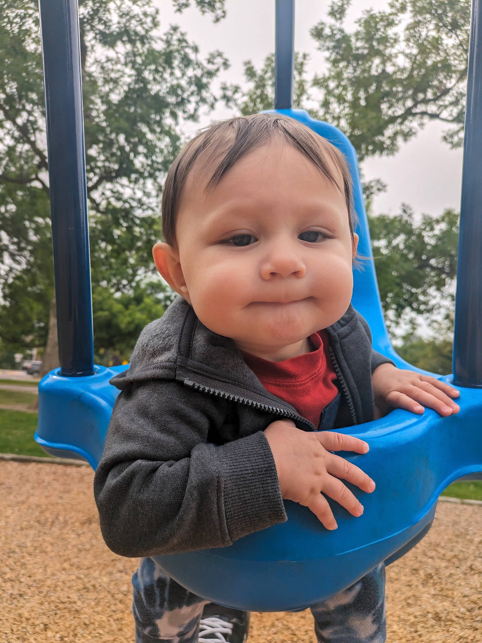 Alistair is registered to the contest to win money with this photo: baby, baby_toddler_clothing, blue, child, city, electric_blue, eye, fun, grass, happy, leisure, outdoor_play_equipment, person, plant, play, playground, recreation, sitting, swing, toddler