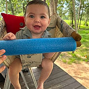 Ricky joined the competition — help win amazing prizes! baby, child, swing, blue_foam, outdoor, greenery, trees, smiling, happy, seat, wooden_floor, sunlight, hand, play, nature, infant, cute, portrait, daylight, summer