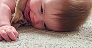 Wyatt is registered to the contest to win money with this photo: baby, smiling, lying_down, carpet, blanket, indoor, child, happy, cute, infant, soft_texture, head, face, skin, clothing, relaxed, toddler, young_child, portrait, cozy