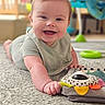 Wyatt is registered to the contest to win money with this photo: baby, smiling, tummy, carpet, toy, playful, infant, child, indoors, happy, cute, reaching, colorful, soft_focus, young_child, person, home, crawling, clothing, bright