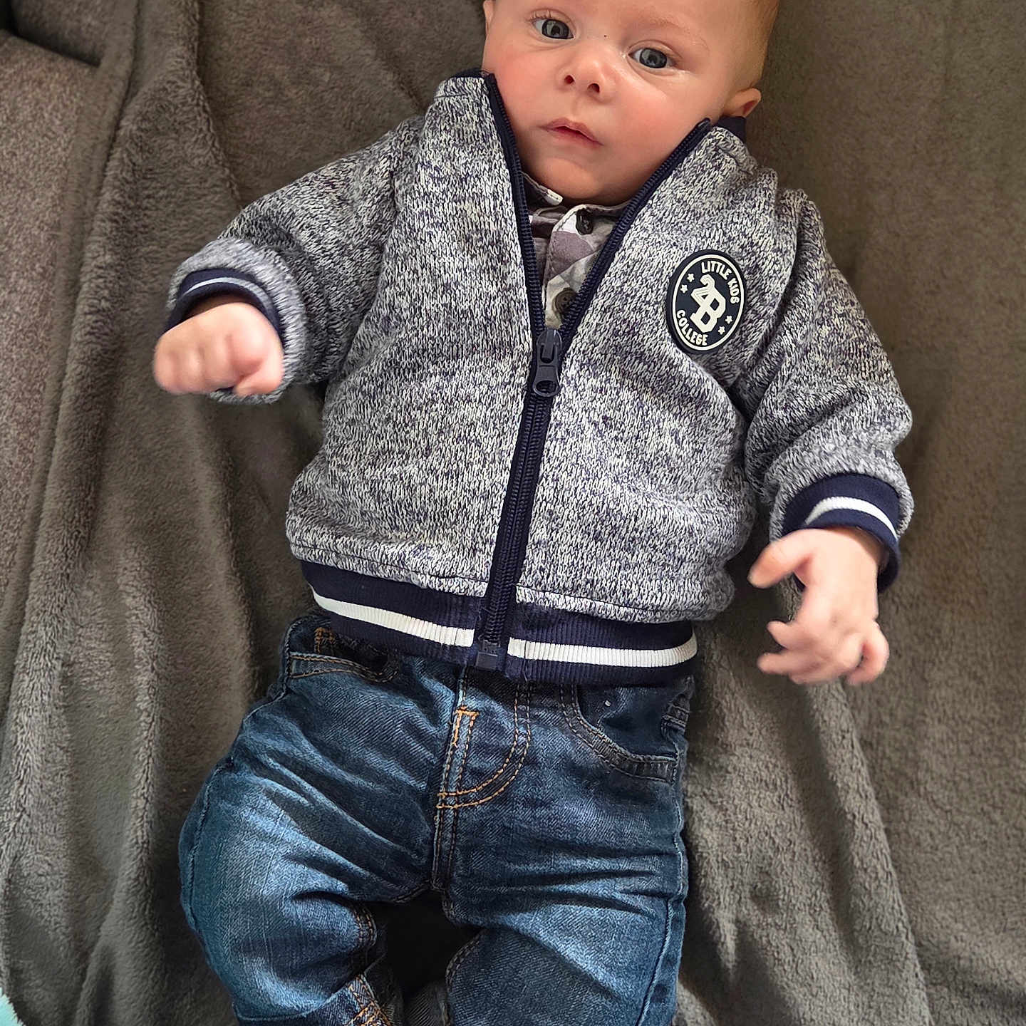 Naël participe au concours pour gagner de l'argent avec cette photo : baby, barefoot, blanket, casual, child, clothing, curious, cute, denim, eyes, face, indoor, infant, jacket, jeans, lying_down, portrait, soft, texture, young
