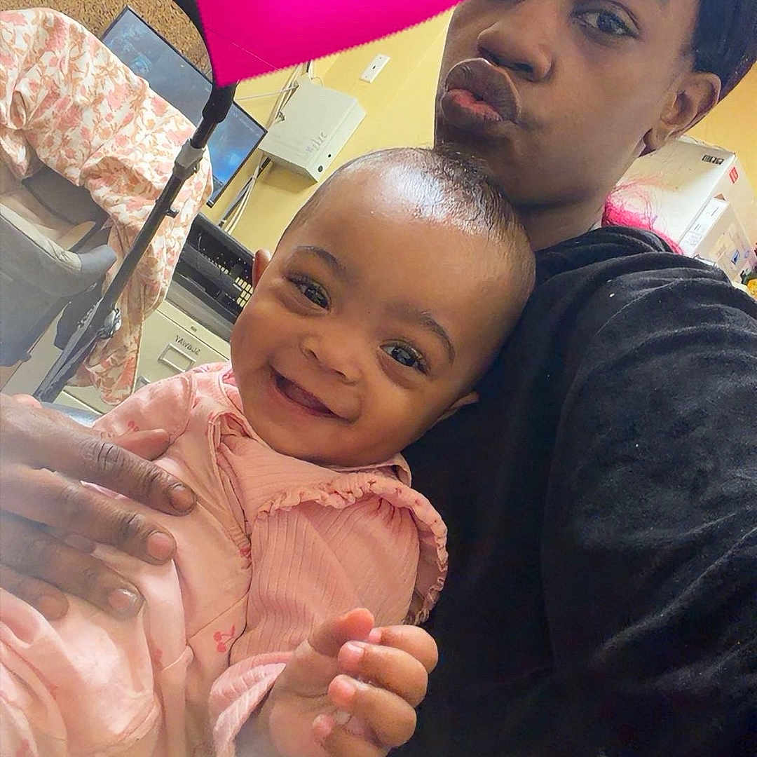 Damarionna is registered to the contest to win money with this photo: baby, child, woman, heart_emoji, pink_clothing, smile, indoor, holding, face, person, expression, happy, cute, love, portrait, head, hand, casual, technology, room