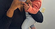 Damarionna is registered to the contest to win money with this photo: woman, baby, mirror, selfie, bathroom, sink, phone, clothing, headband, floor, tile, light_switch, holding, portrait, smiling, person, child, casual, indoor, reflection
