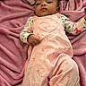 baby, child, infant, pink_overalls, heart_design, blanket, plush, soft_texture, lying_down, cute, face, portrait, clothing, indoor, young_child, sleepwear, comfortable, resting, person, casual