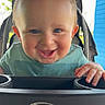 baby, child, smiling, blue_eyes, stroller, graco, happy, outdoor, greenery, blue_wall, hands, clothing, seatbelt, portrait, infant, cute, sunlight, face, person, baby_toy_tray