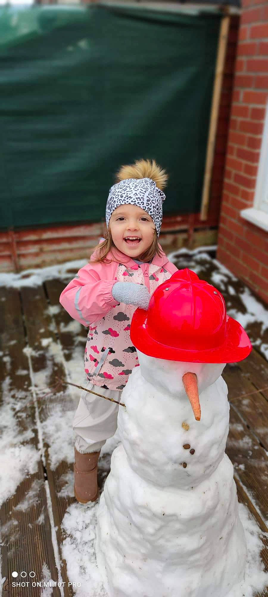 Carla is registered to the contest to win money with this photo: cap, child, event, face, fashion_accessory, freezing, frost, fun, fur, happy, headgear, headwear, joy, leisure, person, pink, playing_in_the_snow, recreation, smile, snow