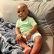 Jahvi is registered to the contest to win money with this photo: architecture, baby, blanket, bodypart, building, clothing, couch, cushion, face, finger, furniture, hand, head, homedecor, person, photography, portrait, shelf, shorts, sitting