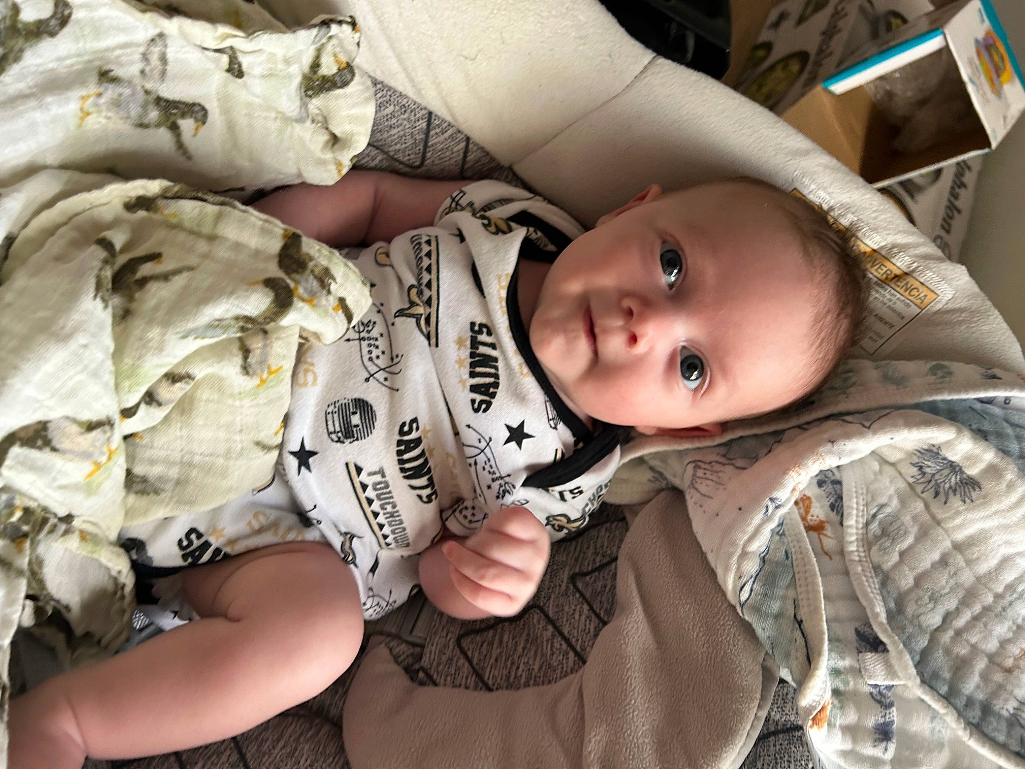 Cooper is registered to the contest to win money with this photo: baby, baby_carriage, baby_products, baby_toddler_clothing, camouflage, cheek, child, comfort, eye, mammal, military_camouflage, mouth, pattern, person, sitting, skin, sleeve, smile, toddler, vertebrate