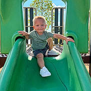 Raymond joined the competition — help win amazing prizes! active, casual_clothing, child, daylight, fun, green_slide, happy, outdoor, person, play, playground, recreation, shorts, slide, smiling, sneakers, summer, sunny, toddler, tree