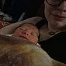Liora is registered to the contest to win money with this photo: newborn, baby, infant, sleeping, adult, woman, glasses, selfie, portrait, blanket, swaddled, cozy, indoors, dim_lighting, bed, close_up, family, parent, peaceful, cuddling