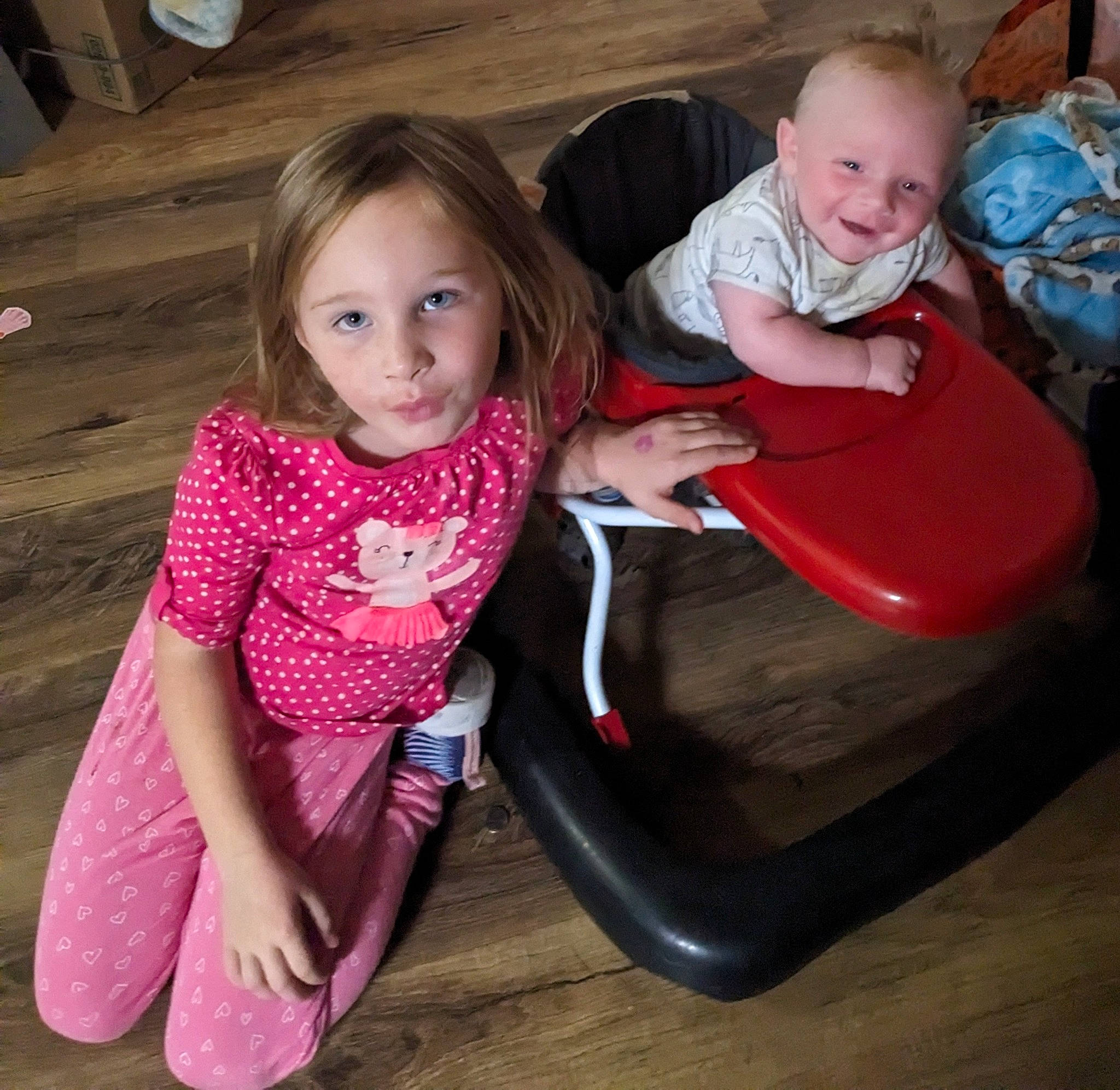 Landin is registered to the contest to win money with this photo: baby_toddler_clothing, clothing, comfort, face, facial_expression, flooring, fun, happy, head, human_body, joy, lap, leg, leisure, mouth, organ, person, pink, skin, smile