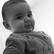 Solann participe au concours pour gagner de l'argent avec cette photo : baby, child, face, portrait, black_and_white, clothing, hand, expression, cute, infant, looking_down, soft_lighting, patterned_clothing, closeup, person, young_child, indoors, cozy, smile, curious
